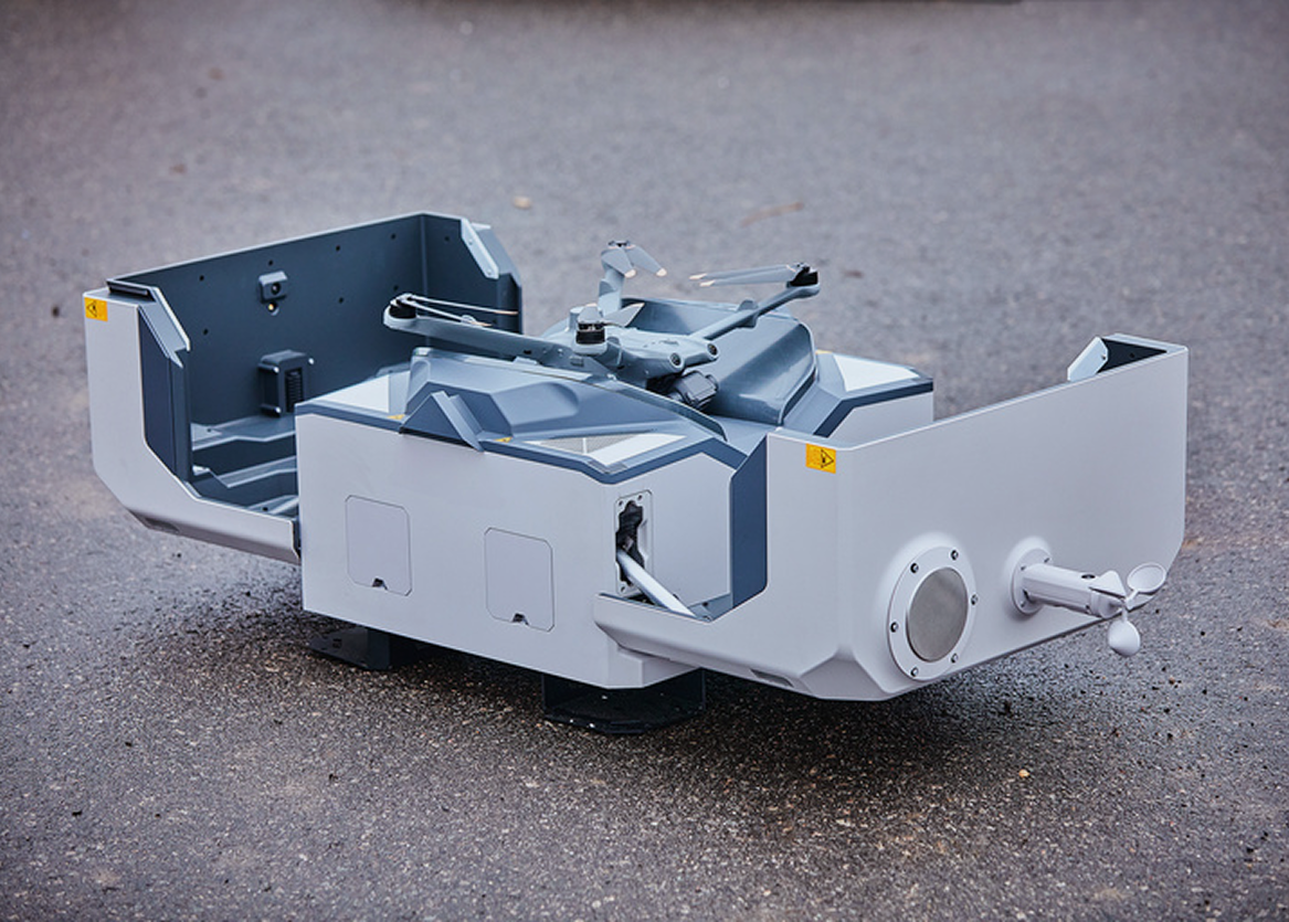 Autonome Sicherheitsdrohne in einer Docking-Station zur 24/7 Überwachung von Industrie-Zäunen und Firmengeländen durch autosecure.